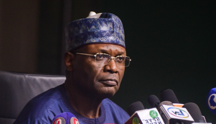 Picture of INEC chairman, a man wearing glasses, hat and blue shirt