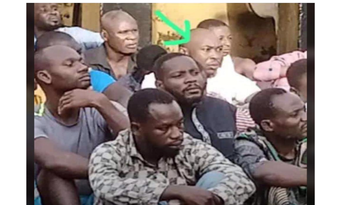 Seun Kuti, son of the late Afrobeat Legend, Fela, is seen with other Suspects in Police Custody sitting on the ground.